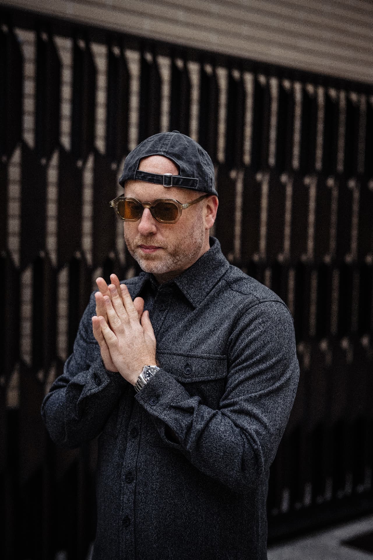 Biblical Beats in amber sunglasses, hands together